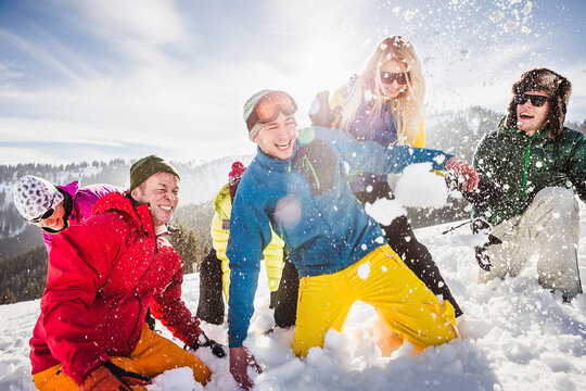 Group of friends having fun playing in the snow in the mountains. Achenkirch, Austria