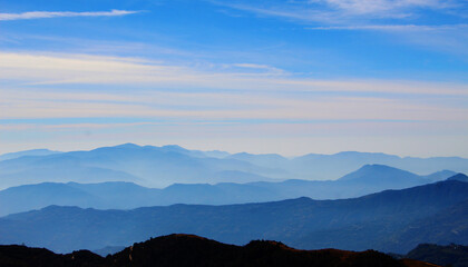 The picturesque foggy mountain landscape. Blue tone mountain landscape. Undulating mountain...