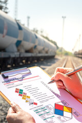 Action of an engineer is checking on chemical hazardous material checklist form with background of...