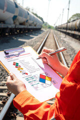 Action of an engineer is checking on chemical hazardous material checklist form with background of...