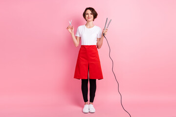 Full length body size photo of hairdresser keeping hot hair straightener scissors smiling isolated...