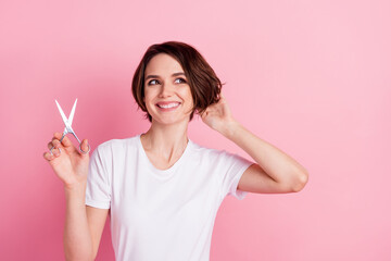 Photo portrait of curious girl cutting hair with scissors smiling looking empty space isolated...