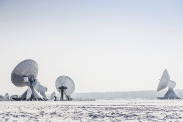 Uplink satellite station in winter landscape with snow and blue skies.