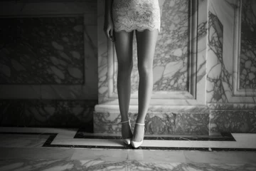 Foto op Plexiglas Schoonheidssalon Black and white photo of legs of young woman on white elegant shoes and white short lace dress