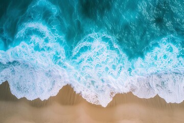 Fototapeta premium Aerial view of ocean waves on the beach Providing a beautiful natural background of summer vacations Aerial top-down view of the sea with blue water waves