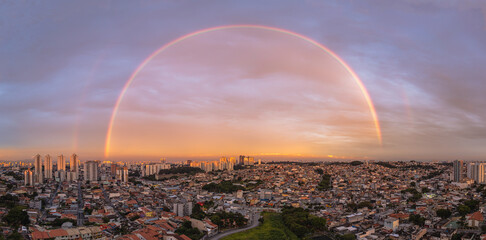 Arco-íris sobre a cidade ao pôr do sol