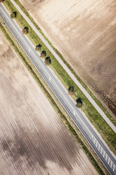 Aerial view of road through countryside with fields on both sides.