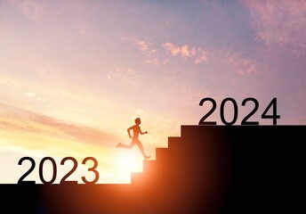 A man running on stairs to 2024 at sunset background
