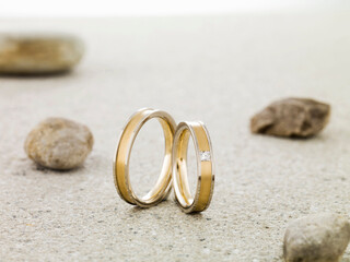 Still life of wedding rings standing on stone table with rocks in the background