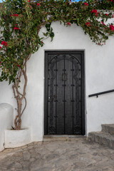 Vejer de la frontera, Cadiz, España - 4 e febrero de 2024: White facade of a traditional Spanish village house with old wooden door carved in Arabic style