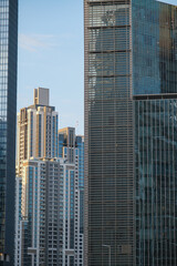 Naklejka premium Futuristic and modern commercial and residential highrise tower skyscraper architecture with glass facades and clean lines in downtown Dubai, United Arab Emirates for millionaires and high society