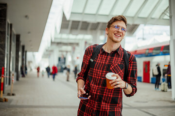 Portrait of a smiling handsome man standing at the train station or a subway
