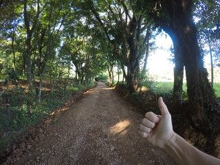 mão fazendo positivo em estrada do interior 