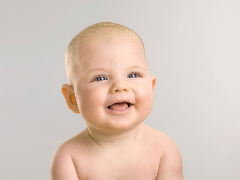 Studio Portrait of baby girl laughing in the camera. Munich, Germany