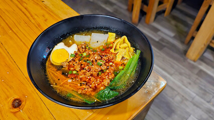 Photo of a bowl of minced pork noodles with boiled eggs, carrot,vegetable and Daikon