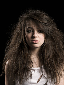 Studio portrait of depressed sad girl with black background