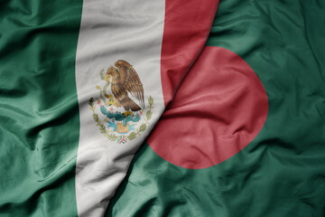 big waving national colorful flag of bangladesh and national flag of mexico .
