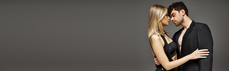 banner of couple embracing each other on grey background, man seducing woman in black dress