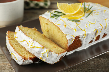 Tasty lemon cake with glaze on wooden table, closeup