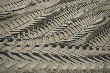 Sand tyre mark background. Tire track shape. Trail lines on dry brown sand pattern. Road construction site backdrop. Heavy machinery imprint. Dried mud vehicle wheel shape.