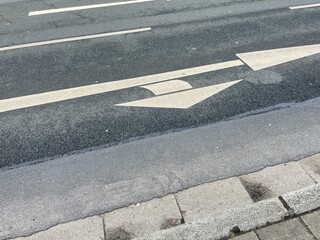 white directional arrows on a road