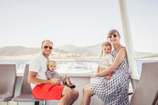Portrait of family of four while traveling on a ferry in the Mediterranean Sea. Korsika, Italy