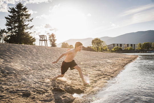 Young boy running to dive in a lake.