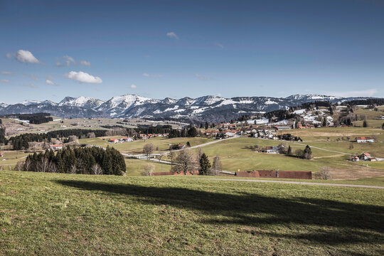 Landscape shot of valley and mountains in the background, with snow up at top. Sulzberg, Austria