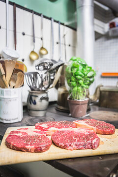 Still life of steaks in the foreground and vintage utensils in the background. Munich, Germany