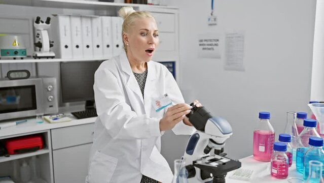 Shocking discovery! young blonde female scientist in uniform, shocked and amazed expression paints her face with fear and disbelief at the lab