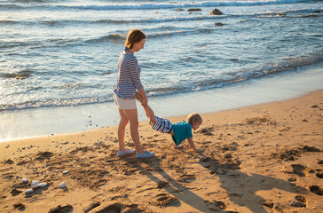 mother and son having fun on the beach. family together on vacation. Healthy lifestyle, activity on...
