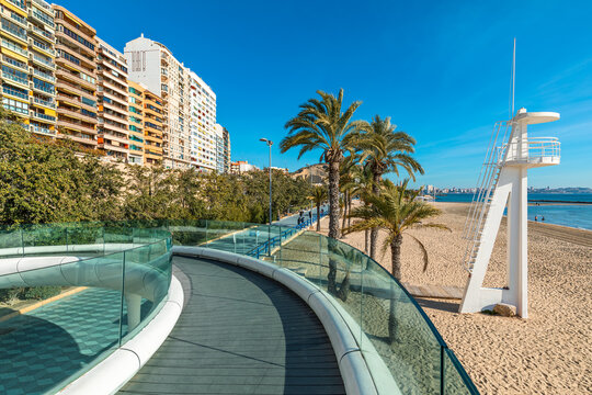 Promenade, buildings and pedestrian bridge along the beach in Alicante, Spain.
