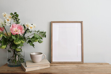 Easter breakfast still life. Blank picture frame mockup. Wooden bench, table composition with cup...