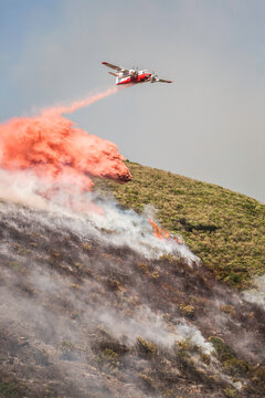Plane dropping flame retardant, ammonia sulfate, onto wild fire in the mountains of Corsica.