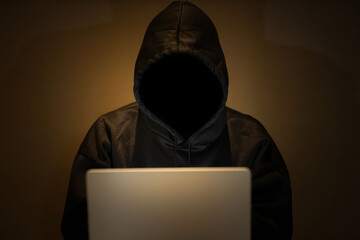 Male hacker in dark room using laptop internet hacking