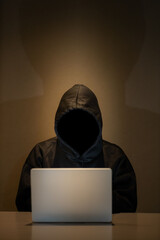 Male hacker in dark room using laptop internet hacking