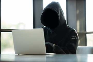 Male hacker in dark room using laptop internet hacking