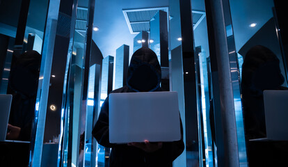 Male hacker in dark room using laptop internet hacking