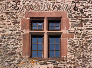 Fototapeta na wymiar Renaissance window frame and anchor plates at the facade of the medieval Neuerburg castle, Eifel region in Germany
