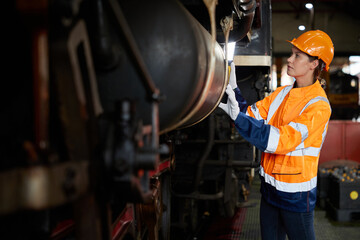 engineer or technician using light stick and checking construction train at station