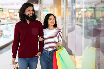 Loving eastern millennial man and woman shopping together