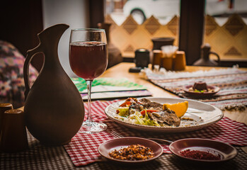 Greek salad and glass of red wine on the oak table