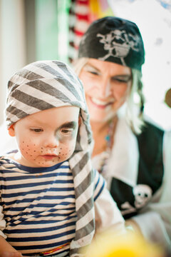 Young boy and his mother both dressed in pirates costume during carnival season. Munich, Germany
