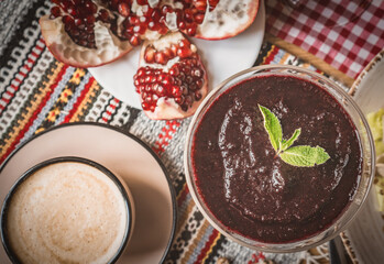 a cup of cocoa, pudding and pomegranate, chocolate puding in the glass with pomegranate.Supangle or pudding
