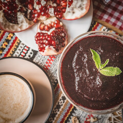 a cup of cocoa, pudding and pomegranate, chocolate puding in the glass with pomegranate.Supangle or pudding