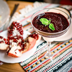 a cup of cocoa, pudding and pomegranate, chocolate puding in the glass with pomegranate.Supangle or pudding