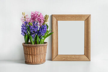 Wooden mock up photo frame and blooming hyacinth on a white table background