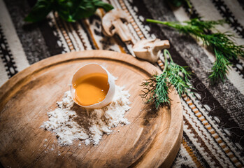 Fresh egg in heap of wholemeal flour on marble table. dough for pizza or pasta. place for text. top view. vertical image.