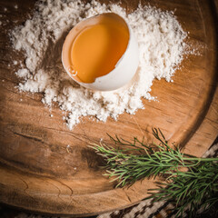 Fresh egg in heap of wholemeal flour on marble table. dough for pizza or pasta. place for text. top view. vertical image.