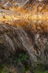 Mirror-Like Reflection of Rio Tinto's Striated Cliffs